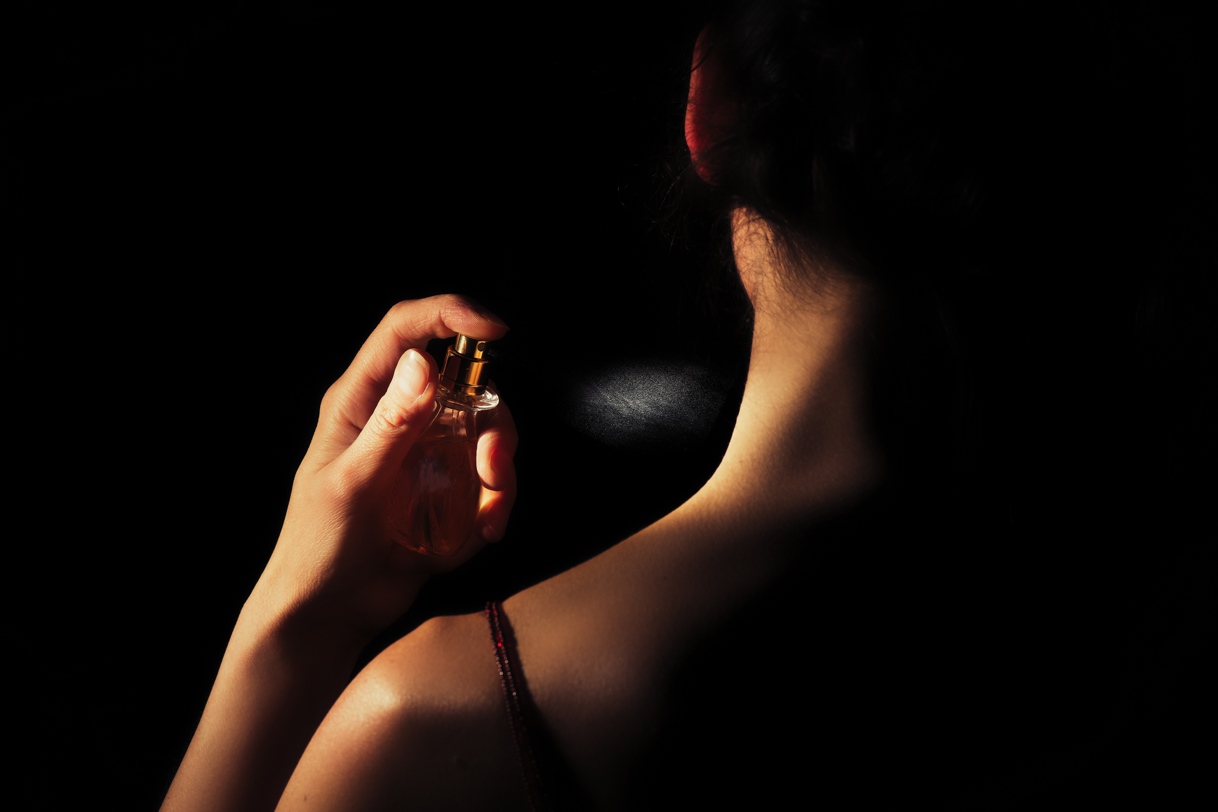 Woman Spraying Perfume on Her Neck 
